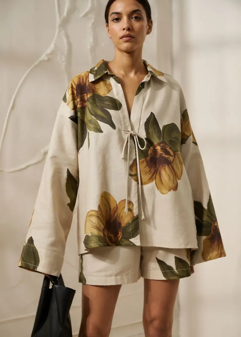 floral white shirt At raflo A model showcases a floral print shirt , highlighting a vibrant summer style women's shirts in kerala