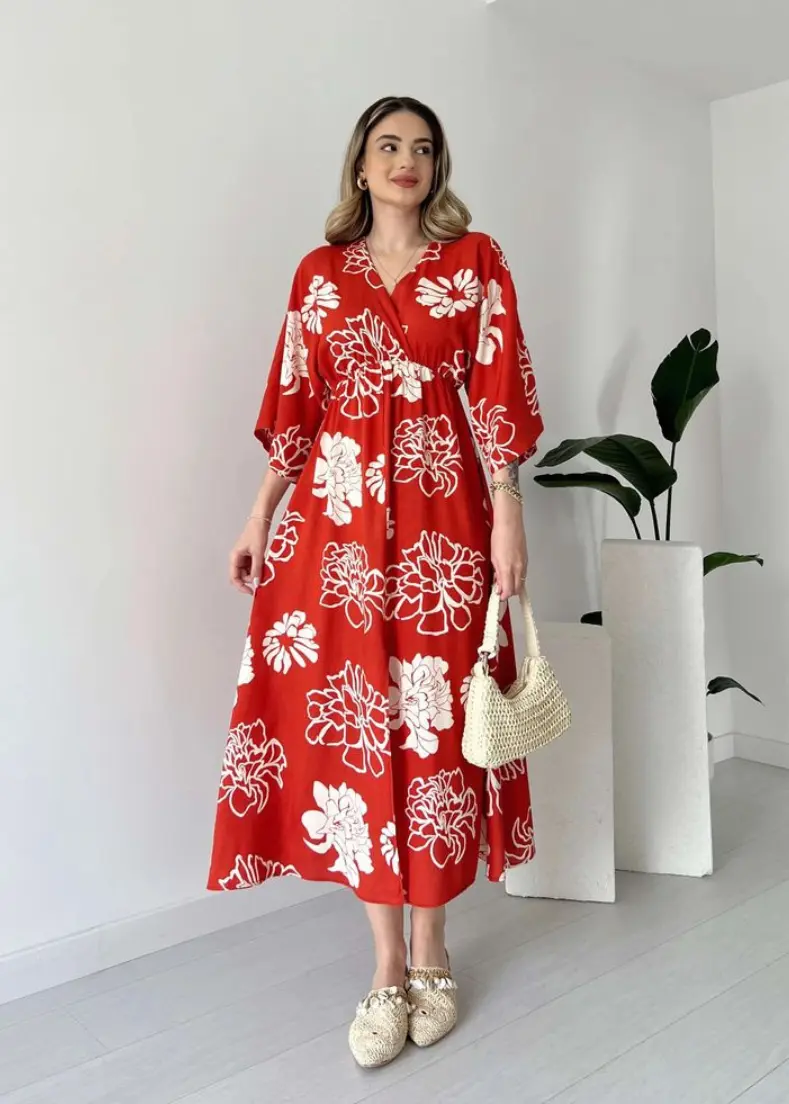 red floral dress at raflo red floral dress paired with white sandals poses elegantly, highlighting her stylish summer attire maxi dresses for women in kerala