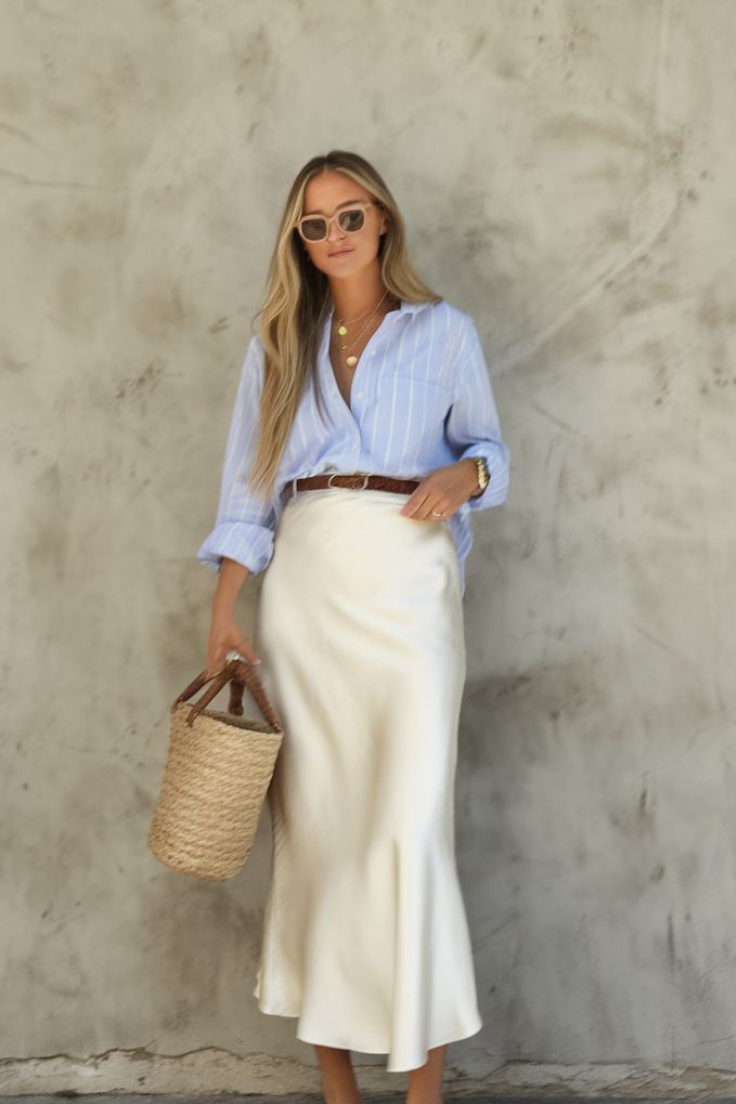 A woman wearing a blue shirt and a white skirt stands confidently, showcasing her stylish outfit. western wear for women in kerla