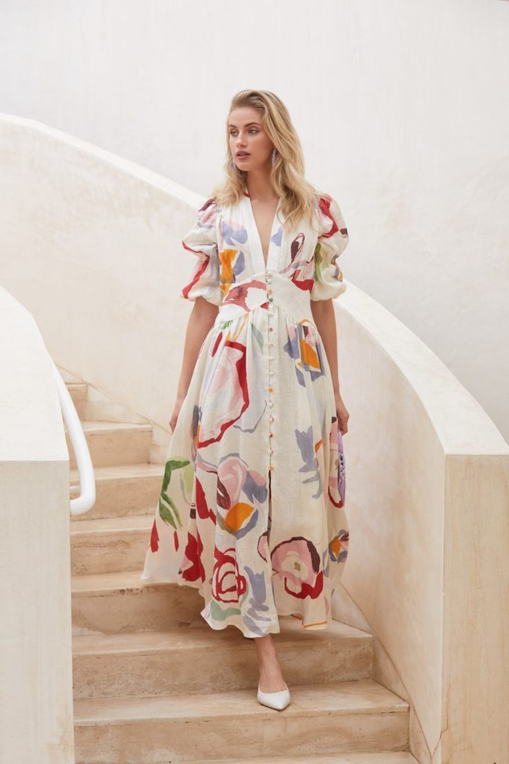 A model poses in a floral dress paired with white shoes, showcasing a vibrant and stylish summer outfit. western wear for women in kerala